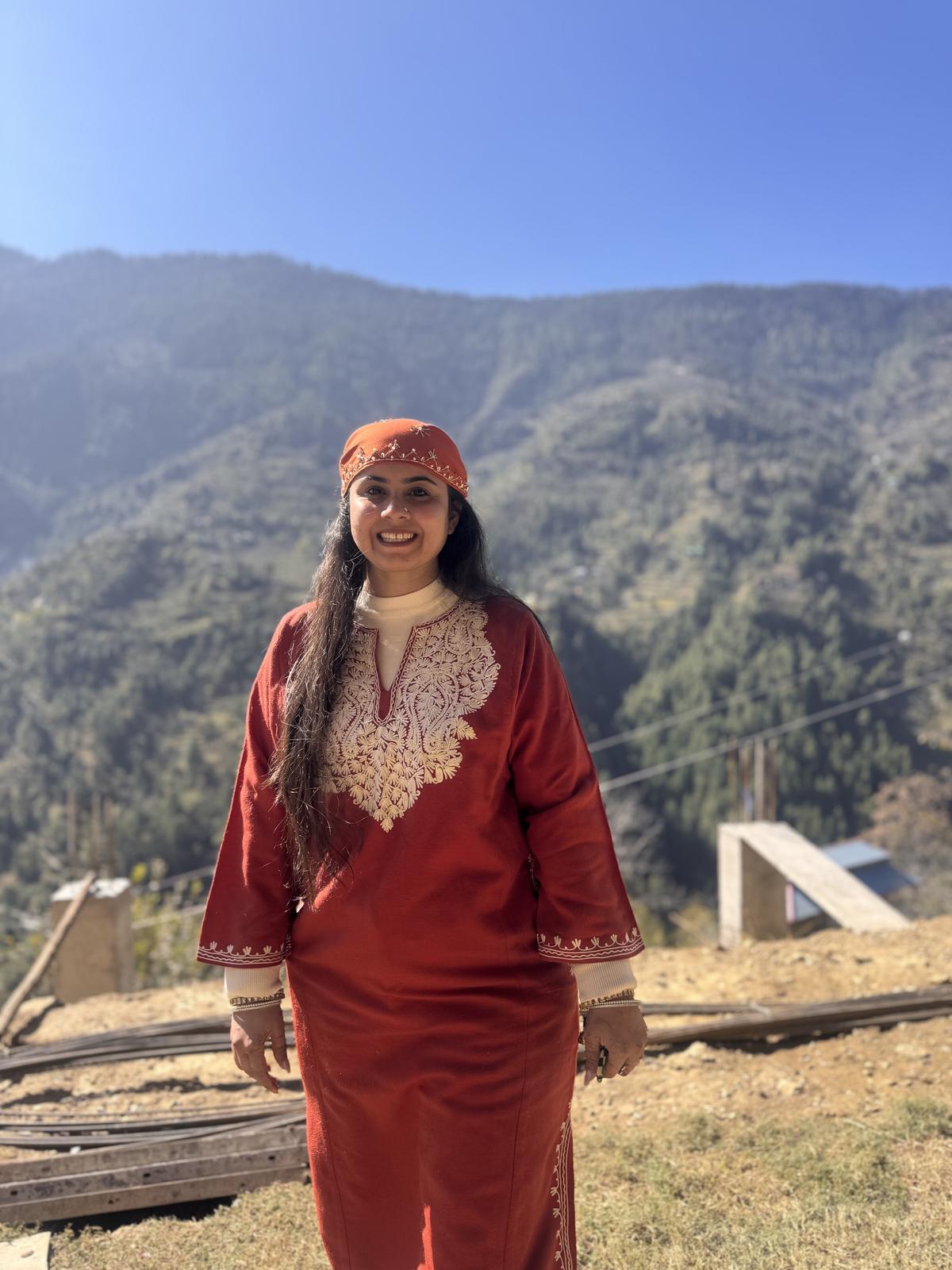 A guest in a red embroidered Himachali dress and cap