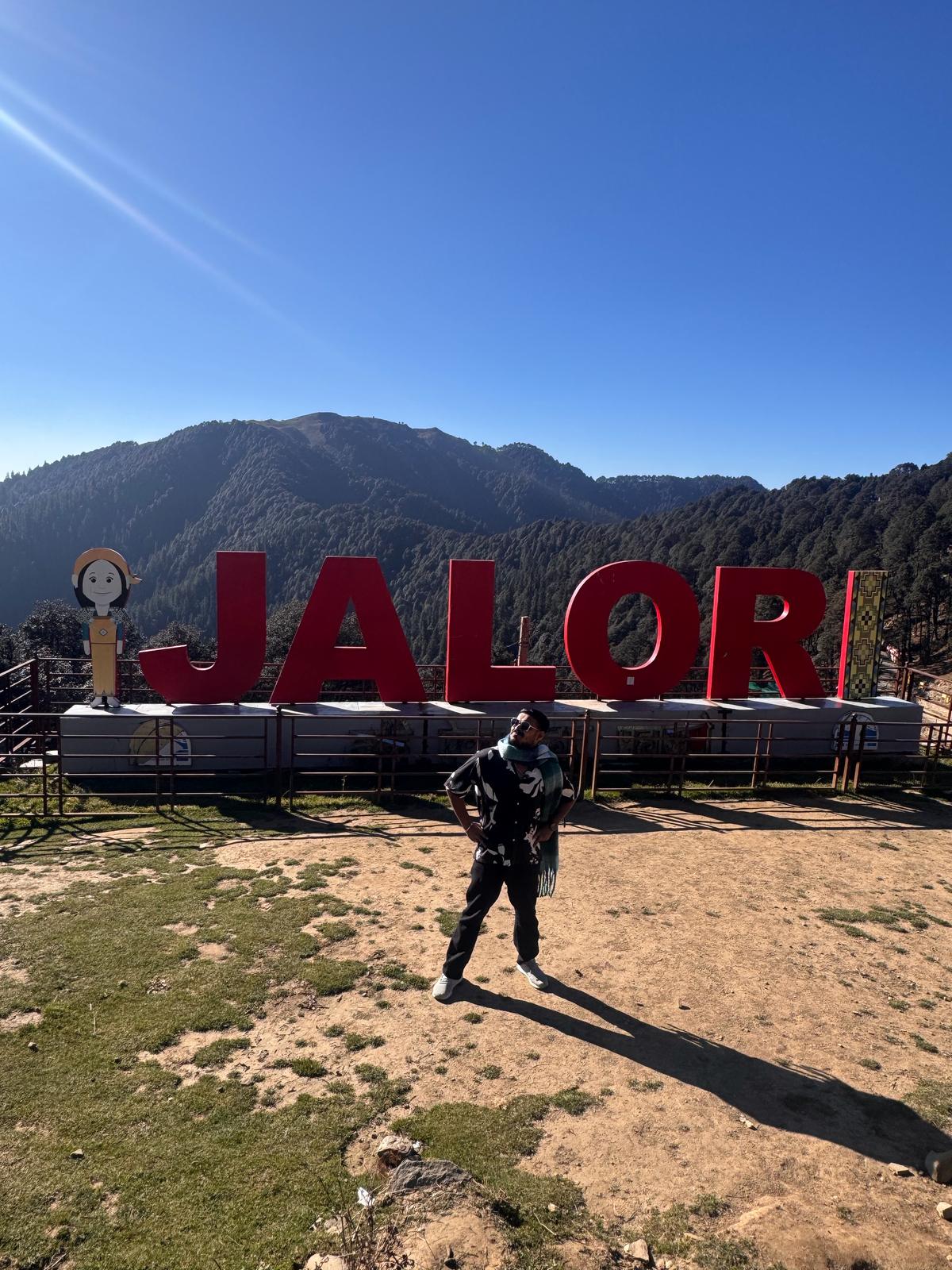 The Jalori Pass sign with mountains behind