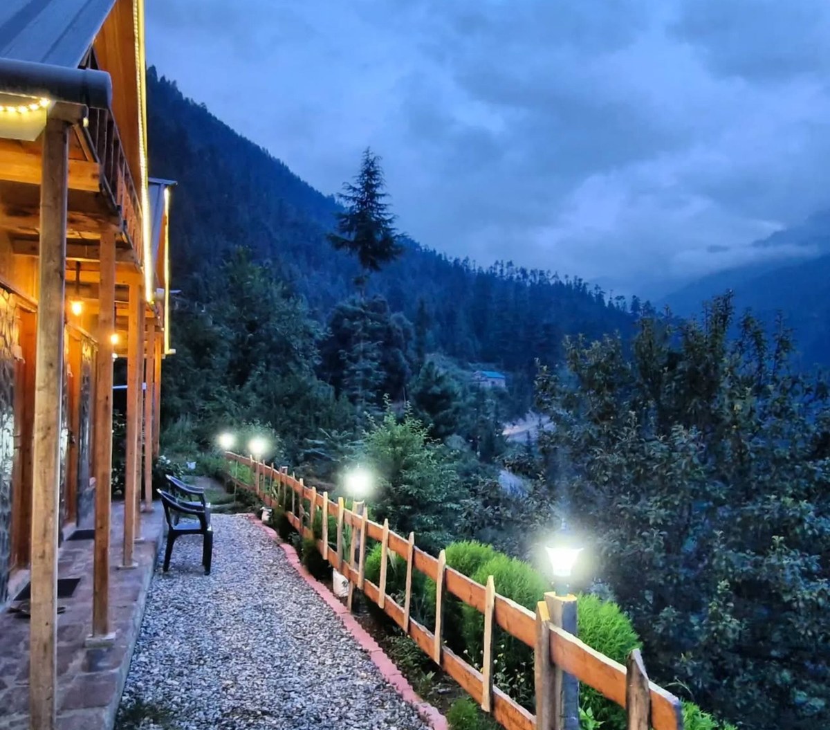 Lantern-lit path beside the cottages at dusk